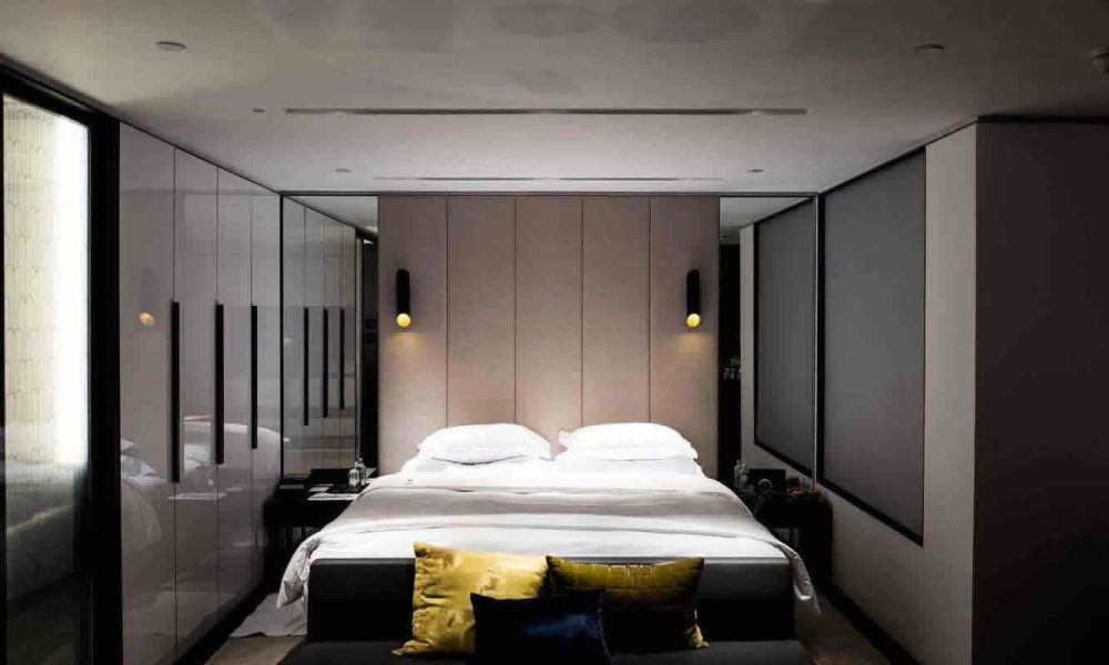 <span class="uk-h4">A contemporary bedroom with a large bed, minimalistic decor, and soft lighting, creating a serene and restful space.</span>